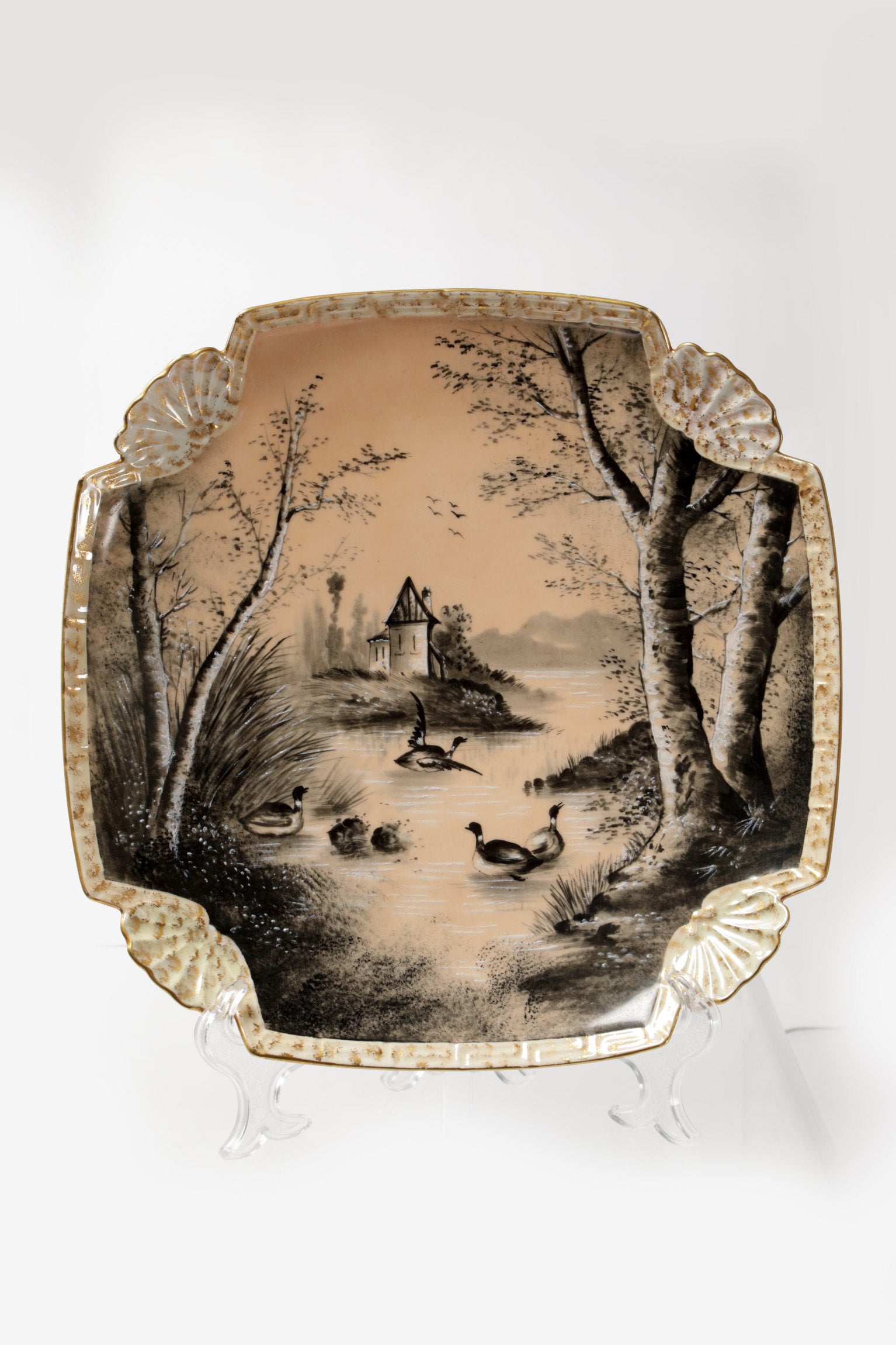 Pair of porcelain plates with lake scene and powder pink background