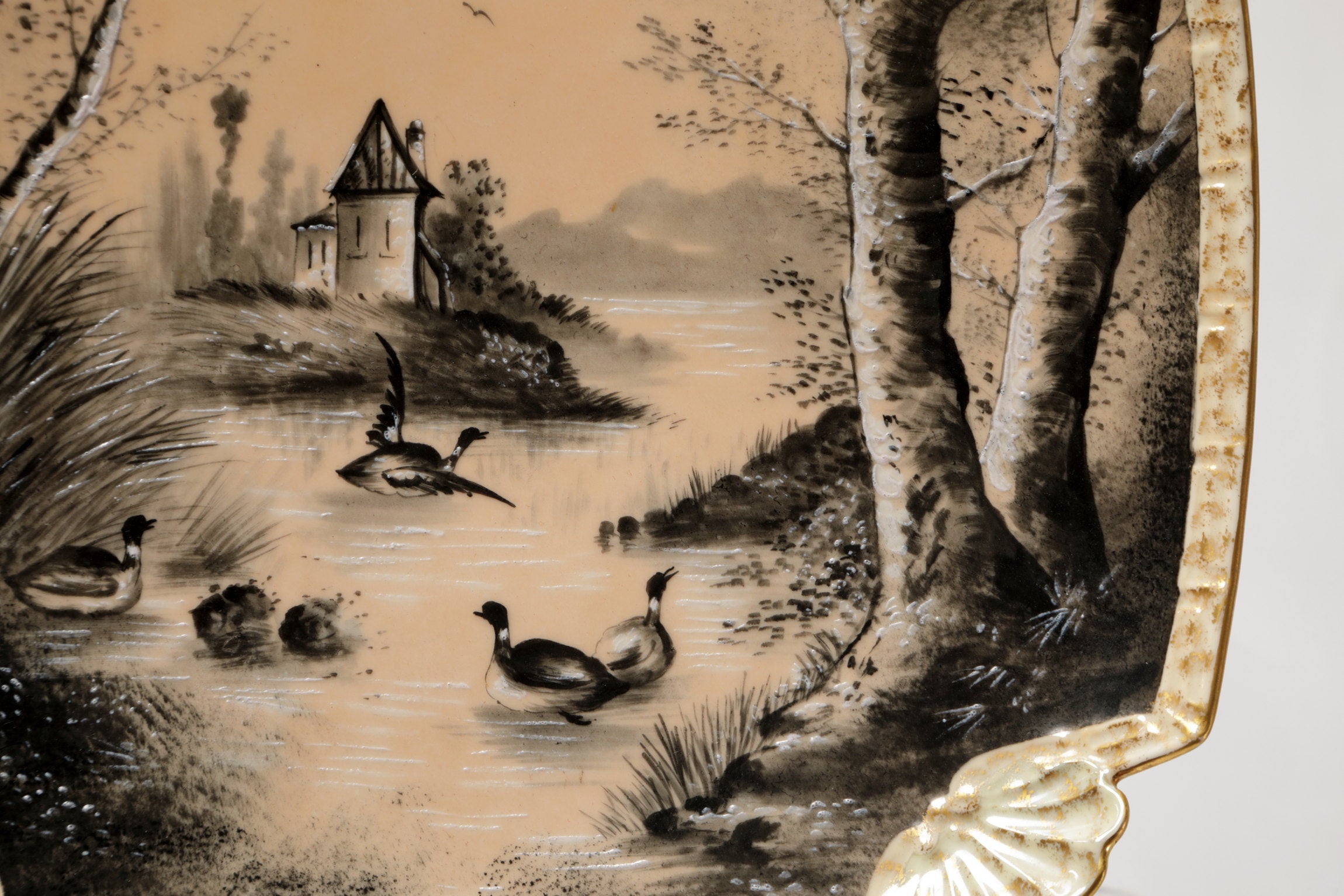 Pair of porcelain plates with lake scene and powder pink background