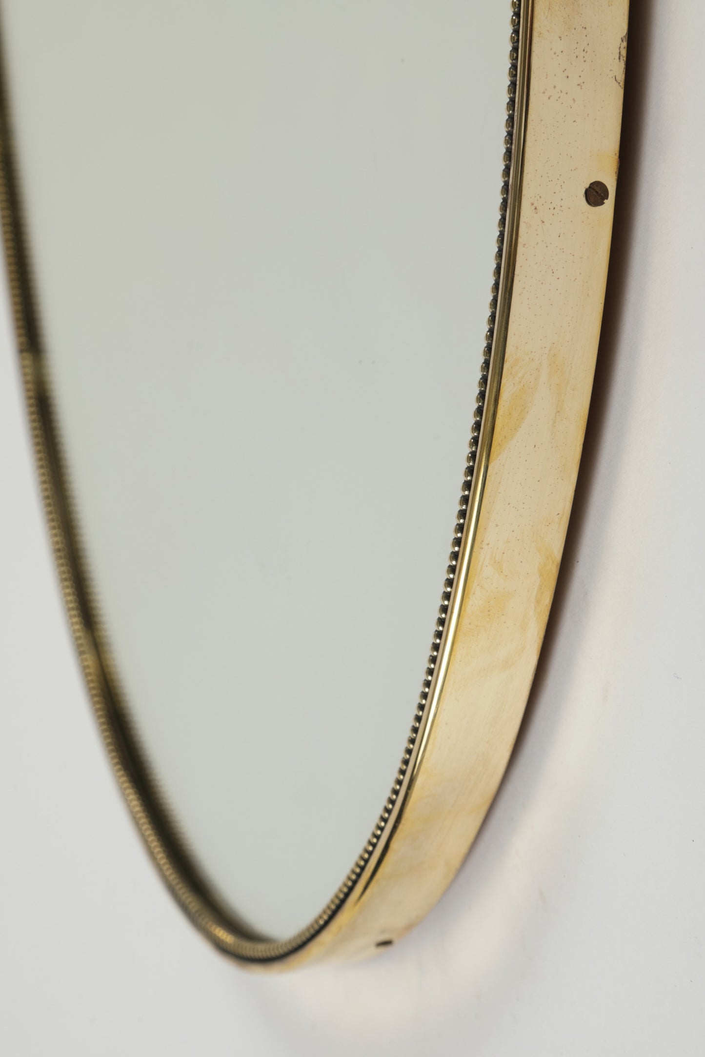 Brass shield mirror with worked edge, 1950s