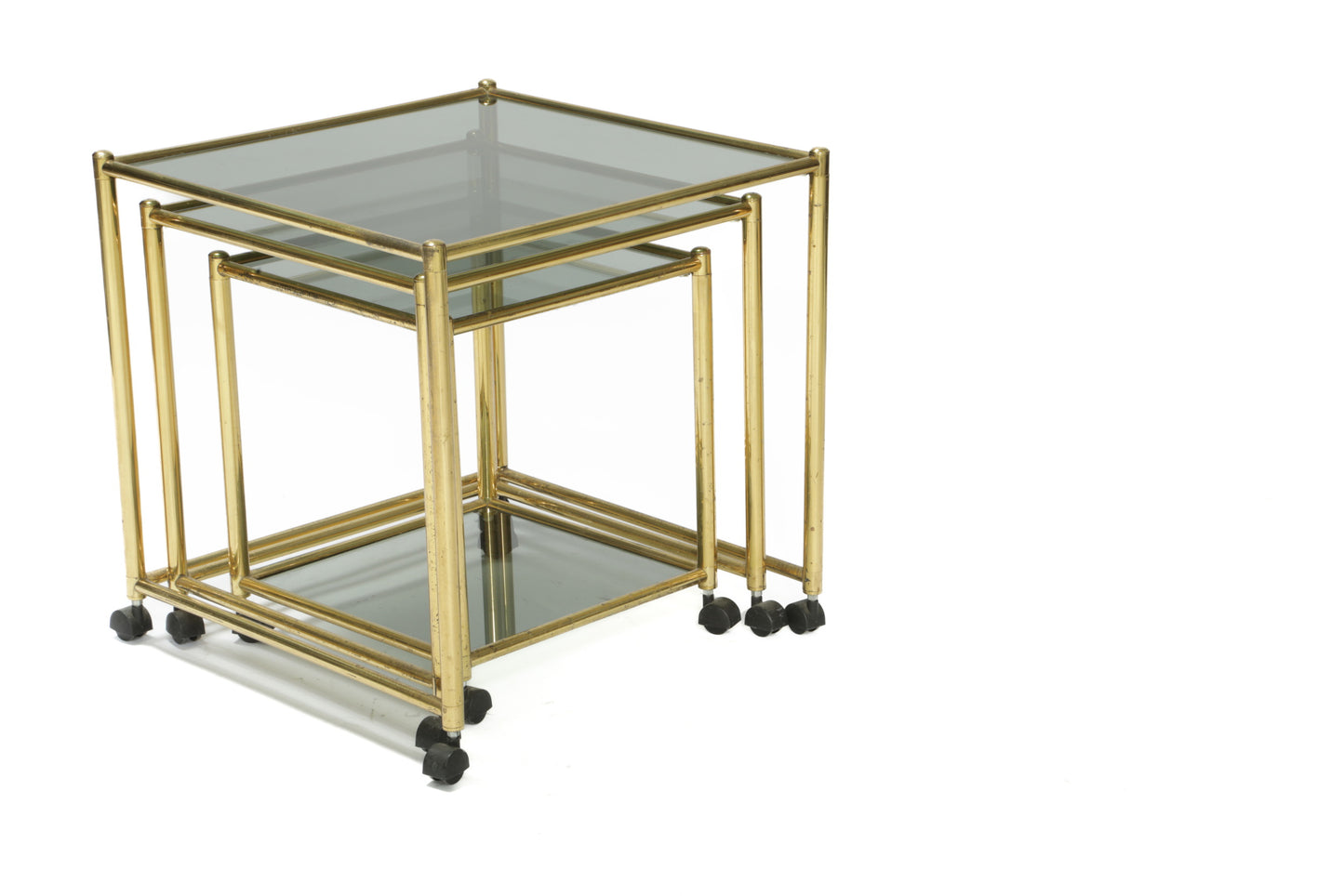 Triptych of brass and smoked glass tables from the 70s