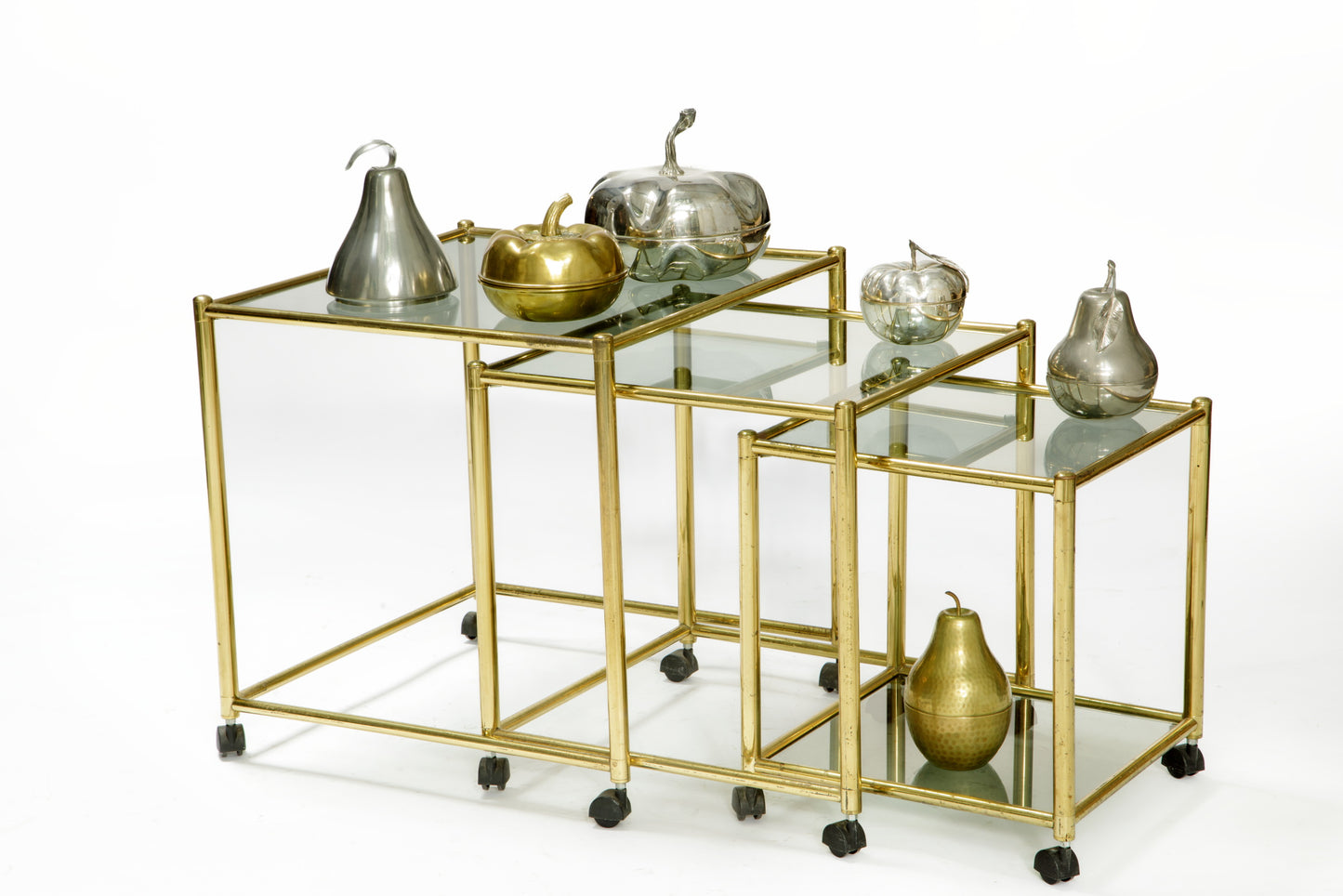 Triptych of brass and smoked glass tables from the 70s